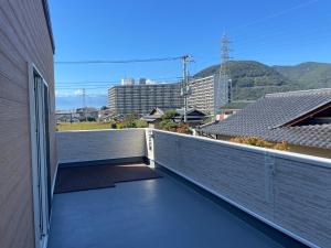 een balkon met uitzicht op gebouwen en bergen bij Glocal Kasugai Onsen - Vacation STAY 64477v in Fuefuki