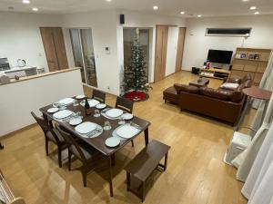een woonkamer met een tafel en een kerstboom bij Glocal Kasugai Onsen - Vacation STAY 64477v in Fuefuki