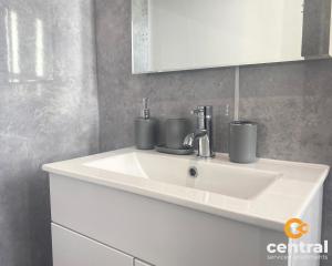 a bathroom sink with two cups on top of it at 2 Bedroom Apartment by Central Serviced Apartments - Monthly Bookings Welcome - FREE Street Parking - WiFi - Smart TV - Ground Level - Family Neighbourhood - Sleeps 4 - 1 Double Bed - 2 Single Beds - Heating 24-7 - Trade Stays - Weekly & Monthly Offers in Dundee