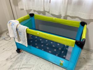 a blue and yellow crib cart with towels on it at AljaLux Sevilla Bormujos in Bormujos