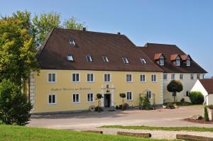 ein großes gelbes Gebäude mit braunem Dach in der Unterkunft Wallfahrtswirt in Wemding