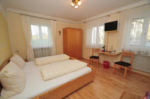 ein Schlafzimmer mit einem Bett und einem Schreibtisch darin in der Unterkunft Wallfahrtswirt in Wemding