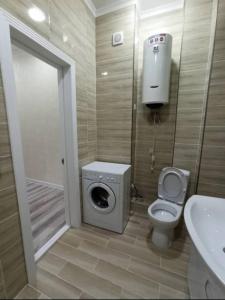a bathroom with a toilet and a shower stall at Kojomkul in Bishkek