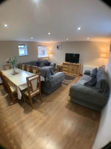 a living room with a table and couches and a dining room at The Dairy, quiet countryside location near York in Wilberfoss