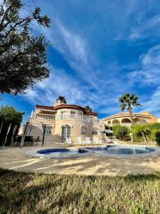 a large building with a palm tree in front of it at Villa Calma in Ciudad Quesada