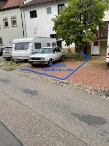 zwei Autos auf einem Parkplatz neben einem Haus geparkt in der Unterkunft Schwarzwald - Haus Luisa - charmantes Altstadthaus bis 4 Personen in Stühlingen