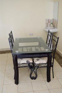 una mesa negra con una tapa de cristal en una silla en ELDORET STAYS en Eldoret