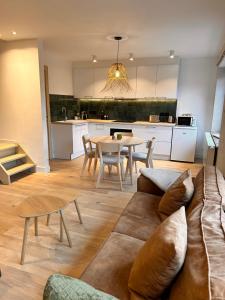 ein Wohnzimmer mit einer Couch und einem Tisch in der Unterkunft Gîte urbain L'Oneux in Hotton