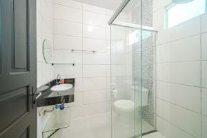 Baño blanco con aseo y lavamanos en Confortavel espaçoso Lof para familia, en Joinville