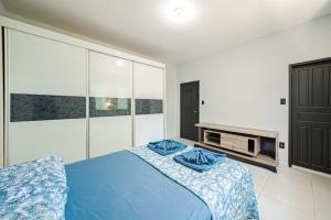 a bedroom with a blue bed and a tv at Confortavel espaçoso Lof para familia in Joinville