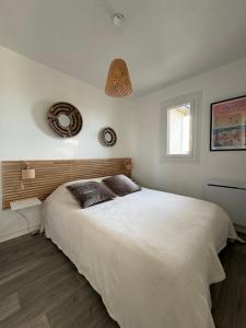a bedroom with a large white bed and a window at Plage Cabourg 7bis in Cabourg