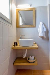 uma casa de banho com um lavatório e um espelho em Empiria House - Agia Irini - Paros em Agia Irini Paros