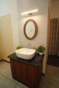 Joann Serviced Apartment في ثيروفالّا: حمام مع حوض أبيض ومرآة