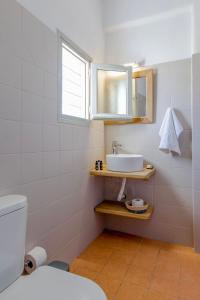 uma casa de banho com um lavatório e um espelho em Empiria House - Agia Irini - Paros em Agia Irini Paros