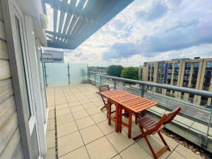 a balcony with a wooden table and two chairs at Captivating 1-Bed Apartment in London in London