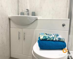 ein Bad mit einem Waschbecken und einem WC mit einem blauen Handtuch in der Unterkunft 1 Bedroom Apartment by Central Serviced Apartments - Modern - FREE Street Parking - Close to University of Dundee - Weekly-Monthly Stay Offers - Wi-Fi - Cosy Little Apartment in Dundee