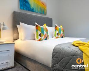 una camera da letto con un grande letto bianco con cuscini di 1 Bedroom Apartment by Central Serviced Apartments - Modern - FREE Street Parking - Close to University of Dundee - Weekly-Monthly Stay Offers - Wi-Fi - Cosy Little Apartment a Dundee