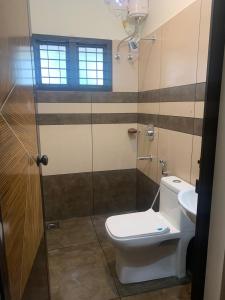 een badkamer met een toilet en een wastafel bij Joann Serviced Apartment in Thiruvalla