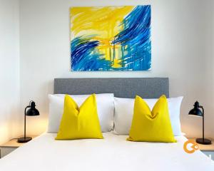 a bedroom with a bed with two yellow pillows at 1 Bedroom Apartment by Central Serviced Apartments - Walk Away From Main Attractions - Parking Available - Close to Bus and Train Station - Easy Access to City Centre - Wi-Fi - Fully Equipped - Monthly-Weekly Stay Offers in Dundee
