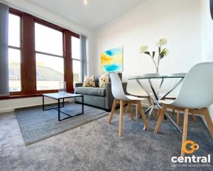 un soggiorno con tavolo in vetro e divano di 1 Bedroom Apartment by Central Serviced Apartments - Walk Away From Main Attractions - Parking Available - Close to Bus and Train Station - Easy Access to City Centre - Wi-Fi - Fully Equipped - Monthly-Weekly Stay Offers a Dundee