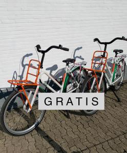 drie fietsen geparkeerd naast een muur met de woorden granen bij Luxury Guest House - Eik aan de dijk in Aalst