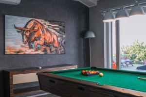 een kamer met een pooltafel en een schilderij van een stier bij Sunrise - The Twin Villa in Široka