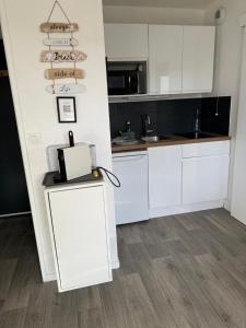 a kitchen with white cabinets and a counter at Plage Cabourg 7bis in Cabourg