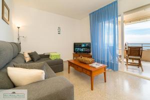 a living room with a couch and a table at Cabo Mar Apartment sea view/pool in El Campello