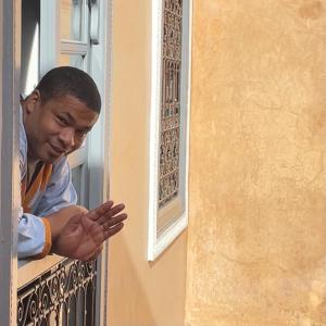 a man looking out of a window at Riad Azawan in Marrakech