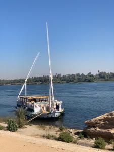 a boat docked on the side of a river at Ben's Dahabeya in Aswan