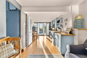 cocina y sala de estar con armarios azules en 139 I Abbey House I Characterful & Peaceful 1BR House w Garden, Rooftop Balcony, Fully Equipped Kitchen and Dedicated Workspace, en Bury Saint Edmunds