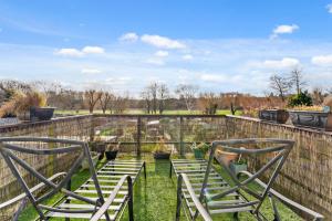 deux chaises assises dans l'herbe à côté d'une clôture dans l'établissement 139 I Abbey House I Characterful & Peaceful 1BR House w Garden, Rooftop Balcony, Fully Equipped Kitchen and Dedicated Workspace, à Bury St Edmunds