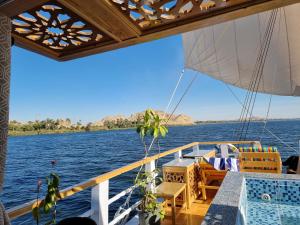 a boat with a table and chairs on the water at Ben's Dahabeya in Aswan