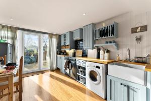 eine Küche mit Waschmaschine und Trockner in der Unterkunft 139 I Abbey House I Characterful & Peaceful 1BR House w Garden, Rooftop Balcony, Fully Equipped Kitchen and Dedicated Workspace in Bury Saint Edmunds + 18 Fotos