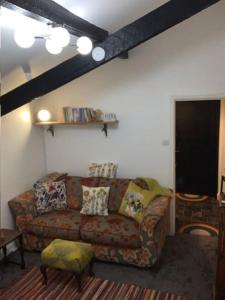 a living room with a couch and a table at Dolgoch Mill House Annexe in Llanfair Caereinion