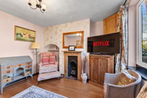 a living room with a tv and a fireplace at 139 I Abbey House I Characterful & Peaceful 1BR House w Garden, Rooftop Balcony, Fully Equipped Kitchen and Dedicated Workspace in Bury Saint Edmunds