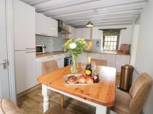 a kitchen with a wooden table with a plate of food at Edmunds Cottage in Bedale