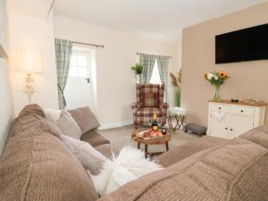 a living room with a couch and a table at Loft Cottage in Bedale