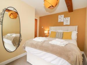 a bedroom with a bed with a large mirror at Loft Cottage in Bedale