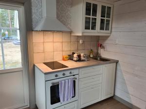 cocina con fogones blancos y fregadero en Charmigt hus och mysigt boende!, en Hudiksvall