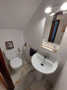 uma casa de banho branca com um WC e um lavatório em El Patio de Lola em Córdoba