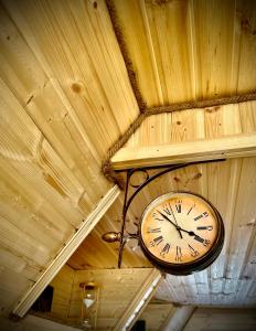 a clock hanging from the ceiling of a building at Hillside Kazbegi in Stepantsminda