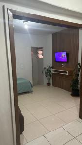 sala de estar con TV de pantalla plana en la pared en Residencial Maldonado Eckert - Enseada - Praia Grande, en São Francisco do Sul