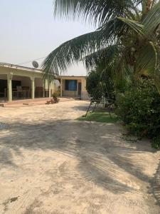 a house with a palm tree in front of it at Inviting 3-Bed Apartment in Kumasi Ashanti Ghana in Dompoasi