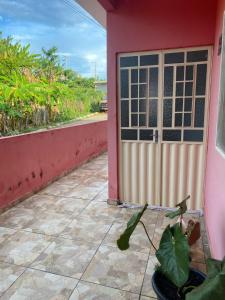 a door to a pink house with a plant next to it at Casa de Everton e Tati in Triunfo