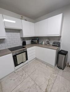 a kitchen with white cabinets and a stove top oven at 3-bed Home For Football Fans in Liverpool