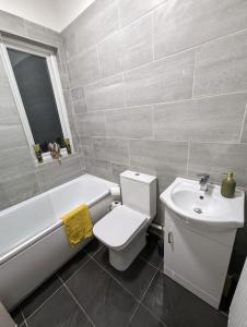 a bathroom with a sink and a toilet and a bath tub at 3-bed Home For Football Fans in Liverpool