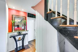 a staircase in a home with a black console table at Welcoming Glen Cove Home about 1 Mi to Public Beach! in Glen Cove
