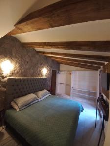 een slaapkamer met een bed met een stenen muur bij Maria Blanca in Santeagueda