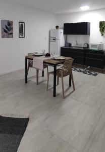 a kitchen with a table and chairs and a refrigerator at Studio no Bairro Cordeiros in Itajaí